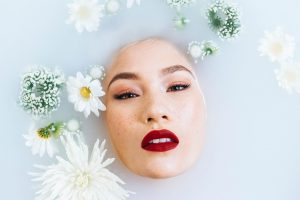 femme sous l'eau visage qui sort avec fleurs qui flottent