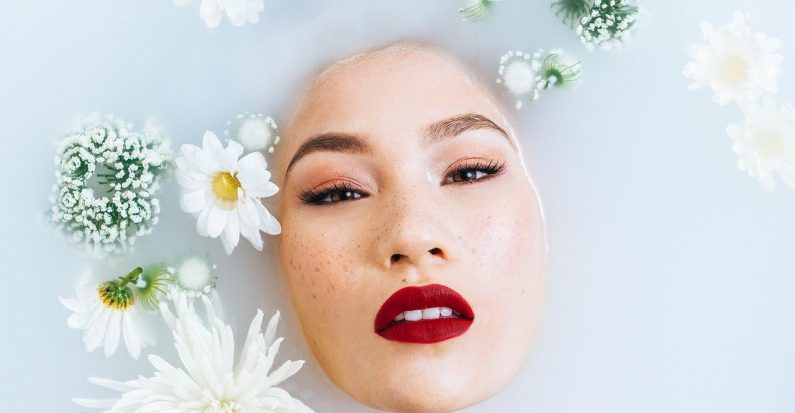 femme sous l'eau visage qui sort avec fleurs qui flottent